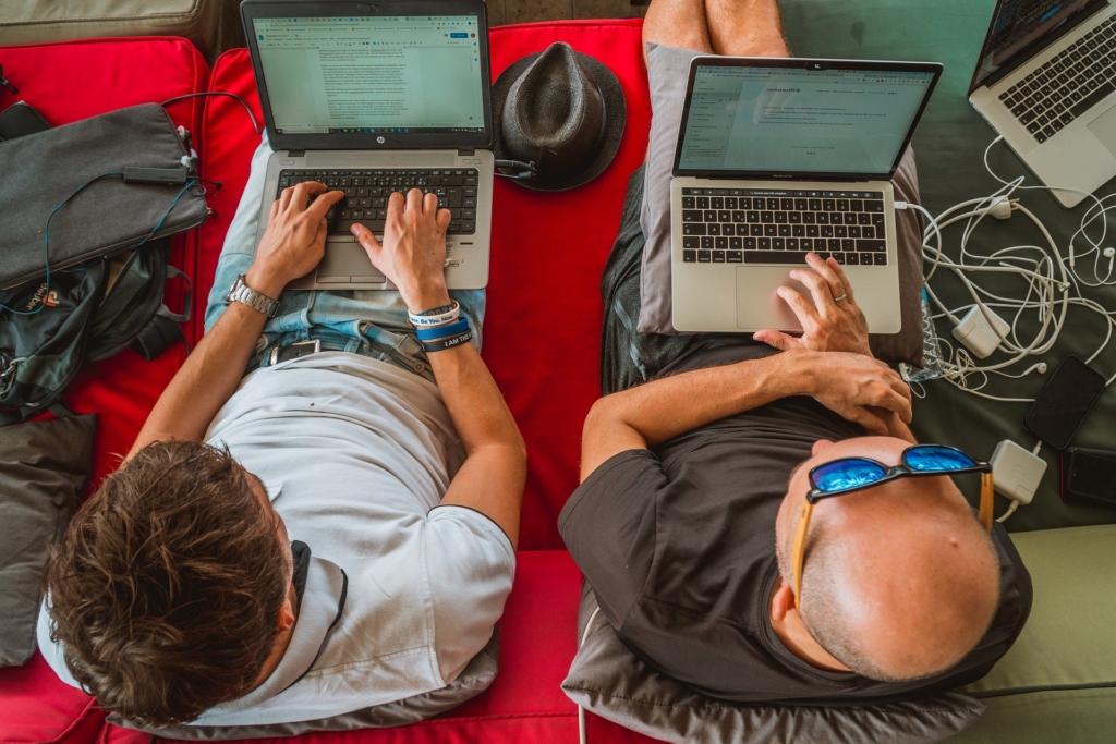 two men working on laptops
